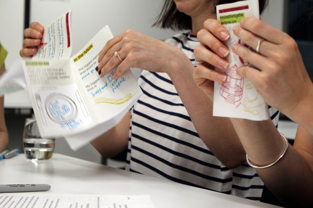 workshop participant folding a booklet